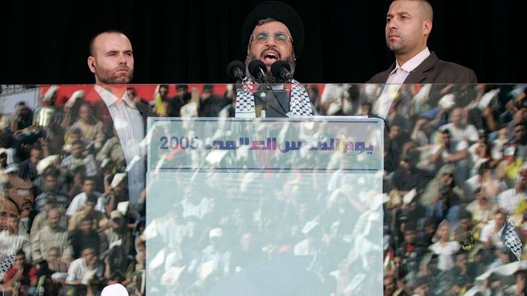 Hezbollah leader Sayyed Hassan Nasrallah, center, escorted by his bodyguard...