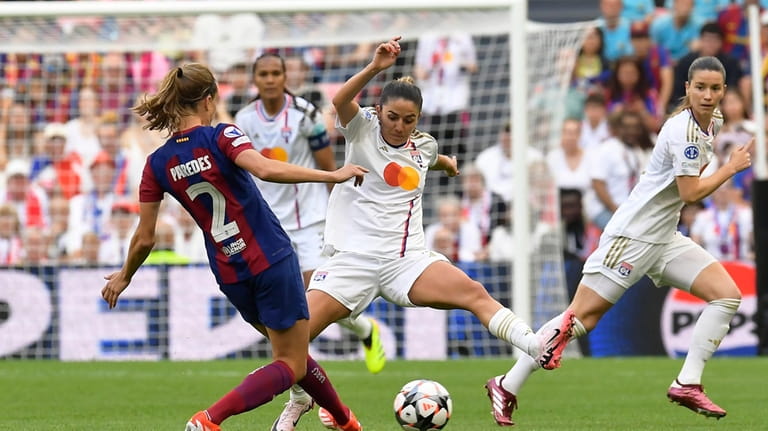 Lyon's Delphine Cascarino tries to block a shot from Barcelona's...