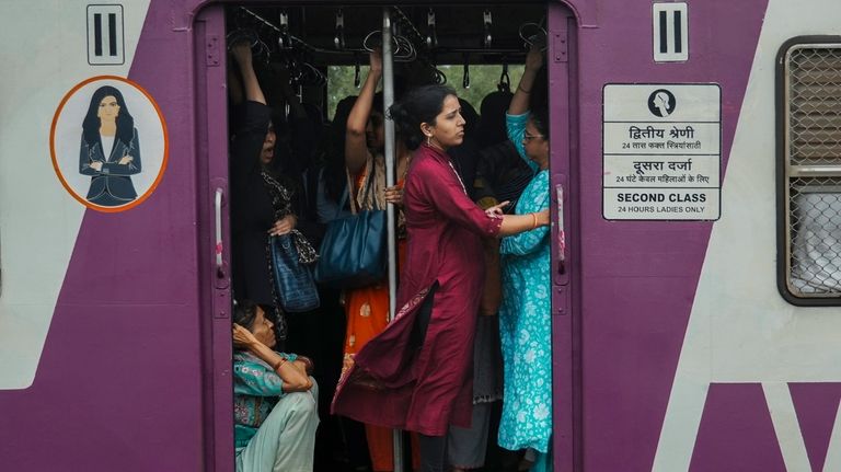 Indian women travel in the ladies compartment of a local...