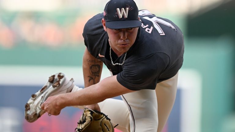 Washington Nationals starting pitcher Mitchell Parker follows through during the...