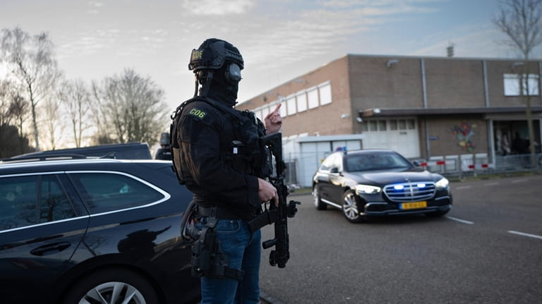 Masked and armed Dutch police guard a transport of some...
