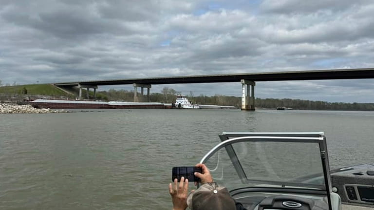 A boater takes a photo of a barge which struck...