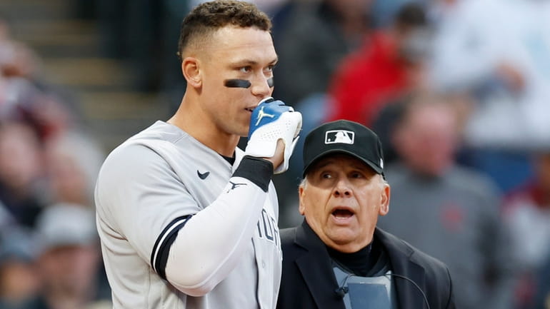Aaron Judge of the Yankees talks with home plat umpire Larry...