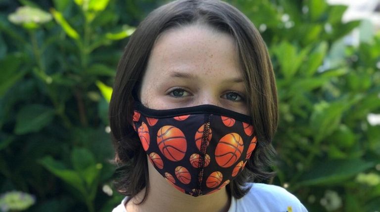 Logan D'Elia, 10, of Bay Shore, wears a reusable mask from...