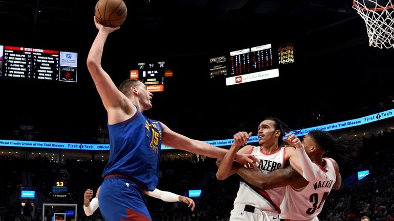 Denver Nuggets center Nikola Jokic, left, holds off Portland Trail...