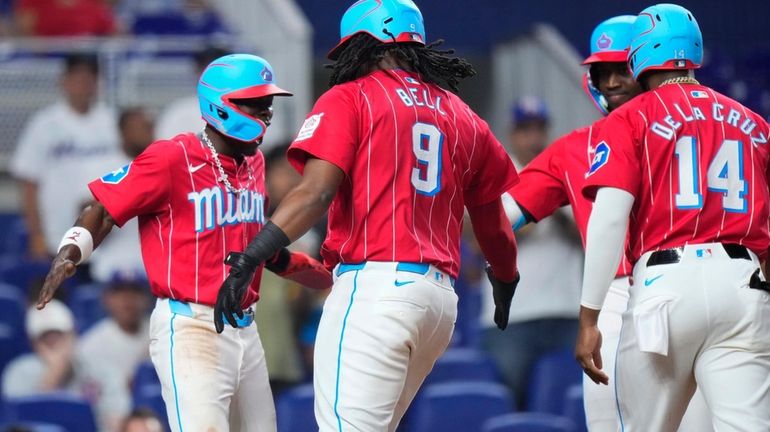 Josh Bell #9 of the Miami Marlins celebrates with teammates...