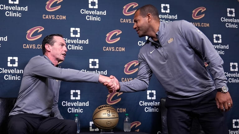 Kenny Atkinson, left, shakes hands with Koby Altman, right, president...