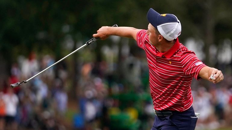 Jordan Spieth throws his ball into the stands after winning...