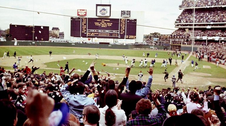 The New York Mets rush the field to celebrate their...