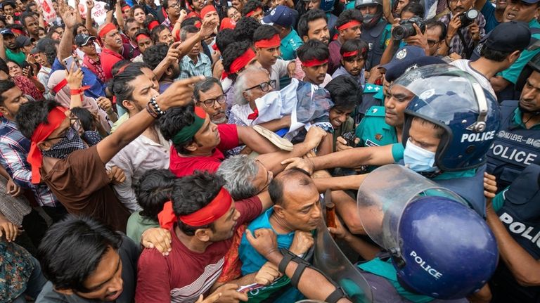 FILE- Activists clash with the police during a march to...