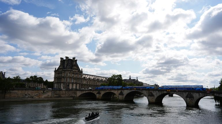 A bomb squad boat navigates the Seine River as officials...