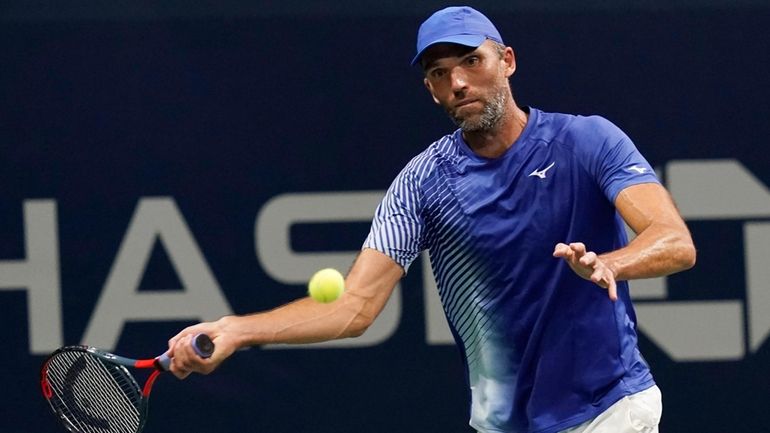 Ivo Karlovic, of Croatia, returns a shot to Richard Gasquet,...