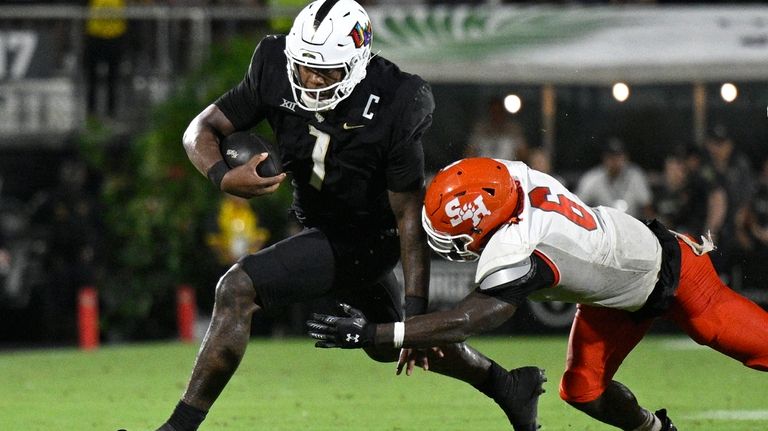 Central Florida quarterback KJ Jefferson (1) scrambles for yardage as...