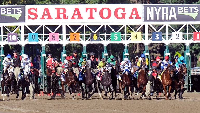 Horses break from the gate at the start of the...