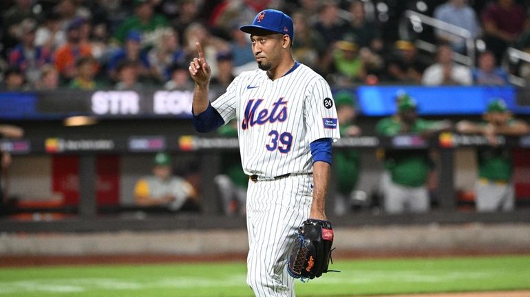 Mets relief pitcher Edwin Diaz gestures as he walks to...