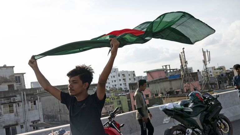 A boy celebrates with a national flag after the resignation...