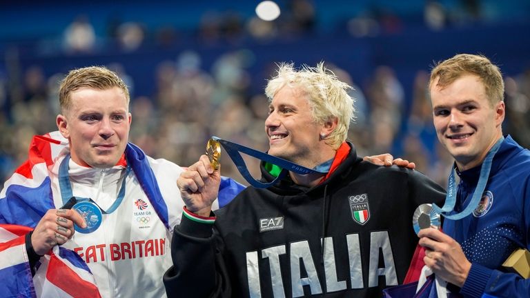 Gold medalist, Nicolo Martinenghi, center, of Italy, poses with silver...