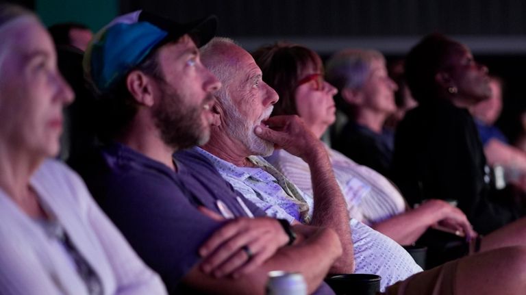 People watch the presidential debate between Republican presidential nominee former...