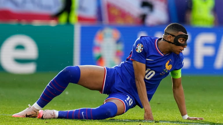 Kylian Mbappe of France goes down on the pitch during...