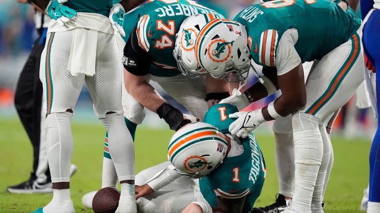 Miami Dolphins quarterback Tua Tagovailoa (1) lies on the field...