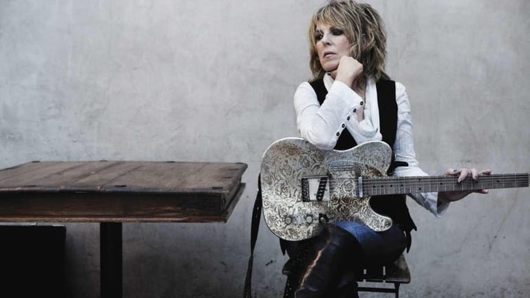 Lucinda Williams sits with her guitar for a photo shoot....