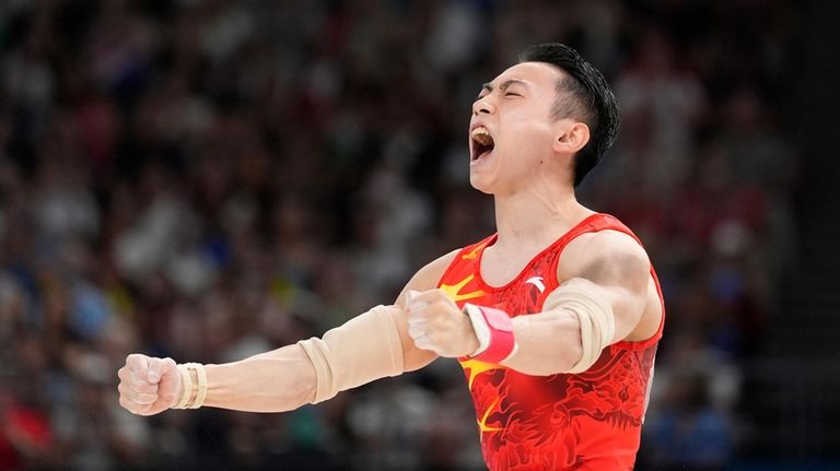 Zou Jingyuan, of China, celebrates after completing his routine in...