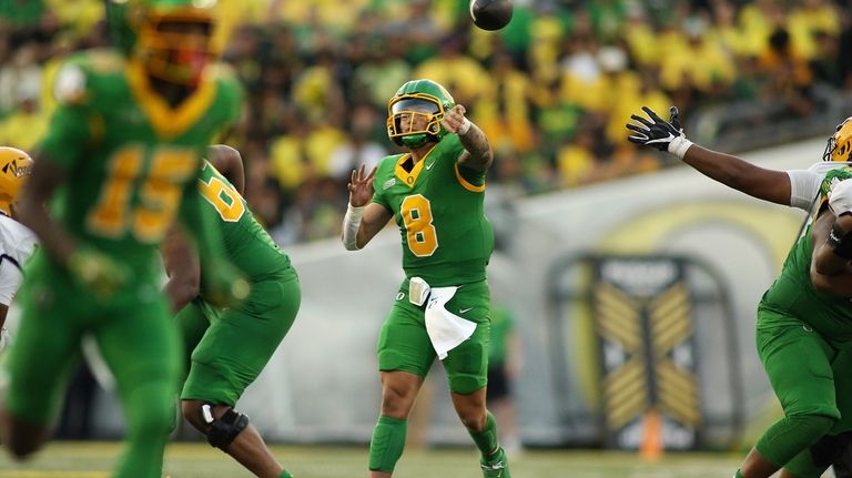 Oregon quarterback Dillon Gabriel, center, throws a pass during the...