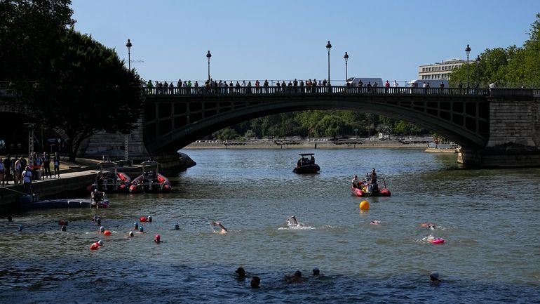 People swim in the Seine river after Paris Mayor Anne...