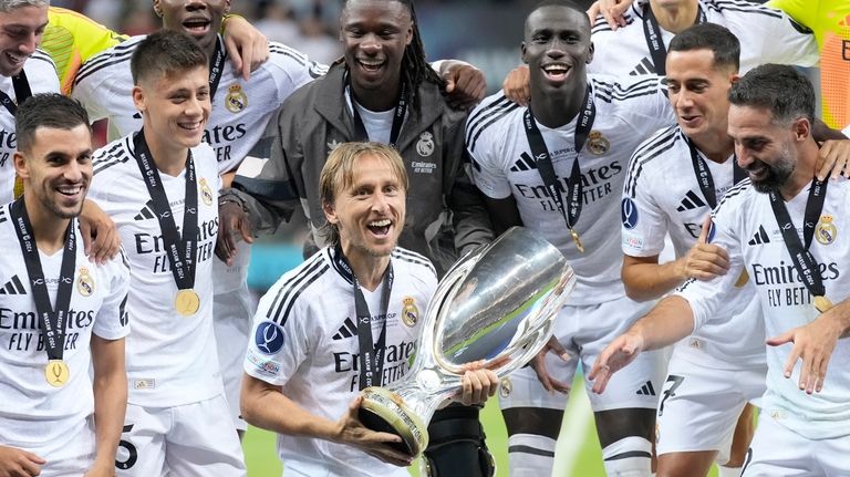 Real Madrid's Luka Modric holds the trophy after winning the...