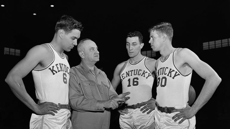 Kentucky basketball coach Adolph Rupp talks to players, from left,...