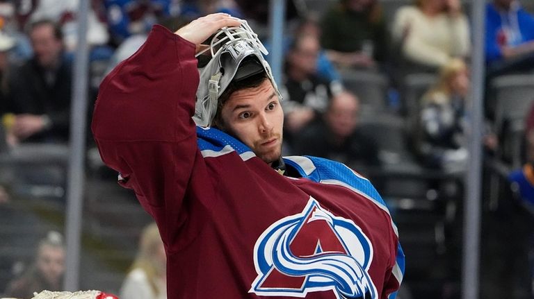 Colorado Avalanche goaltender Alexandar Georgiev adjusts his helmet during a...