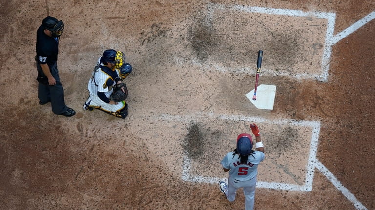 Washington Nationals' CJ Abrams, right, tosses his bat after hitting...