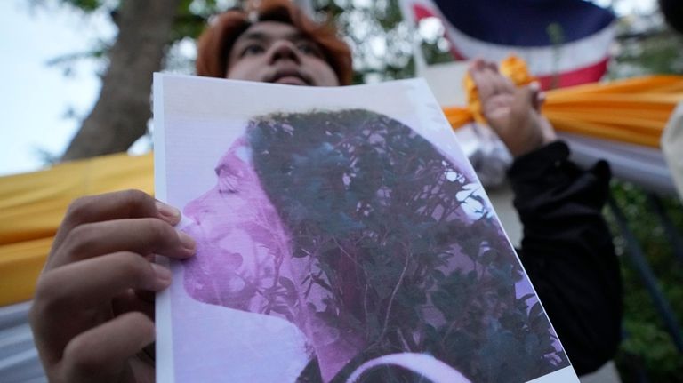 A Thai activist holds a portrait of Netiporn Sanesangkhom, a...