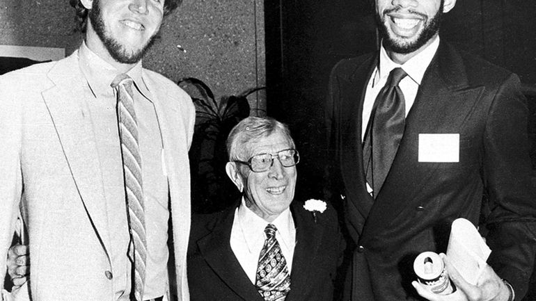 Former UCLA NCAA college basketball coach John Wooden, center, is...