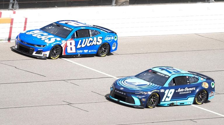 Kyle Busch (18) and Martin Truex Jr. (19) drive during...