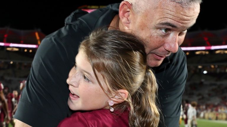 Florida State head coach Mike Norvell hugs his daughter Mila...