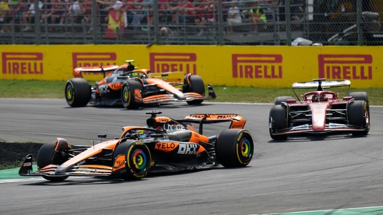 McLaren driver Oscar Piastri of Australia steers his car Ferrari...