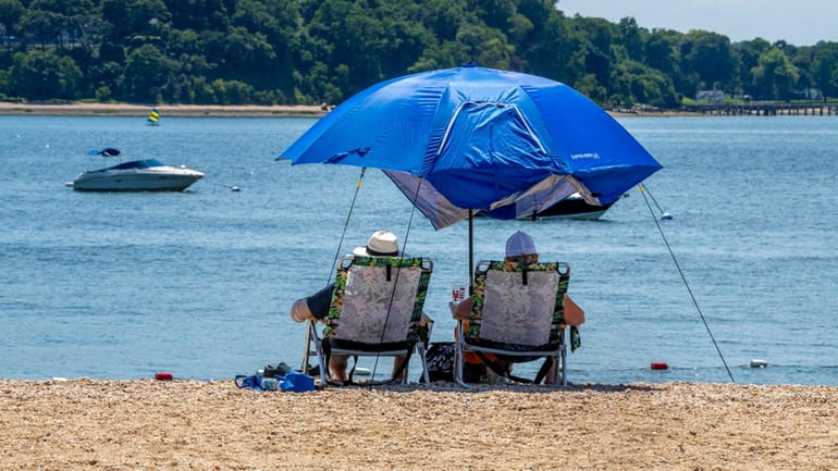 People enjoy the view on the beach at West Neck...