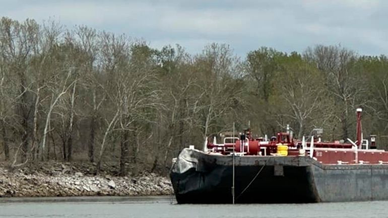 Damage is seen on a barge after it struck a...