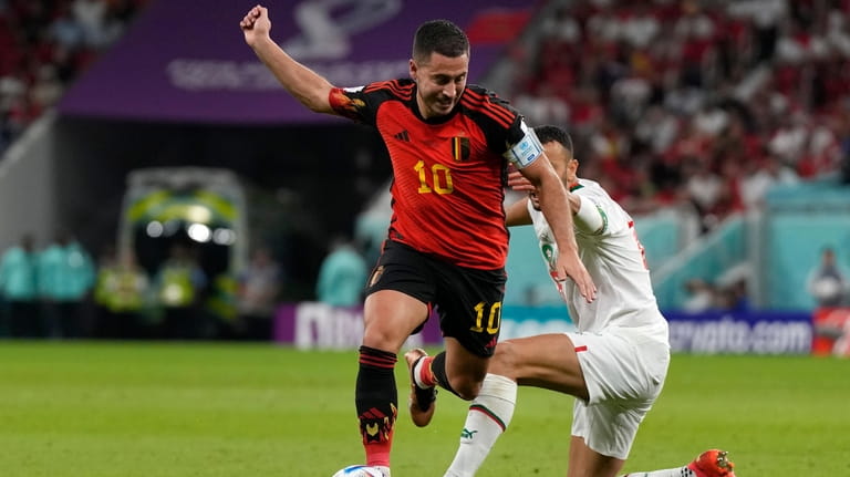 Morocco's Romain Saiss, right, fights for the ball with Belgium's...