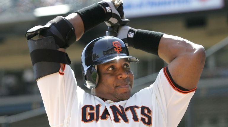 The Giants' Barry Bonds warms up in the on deck...