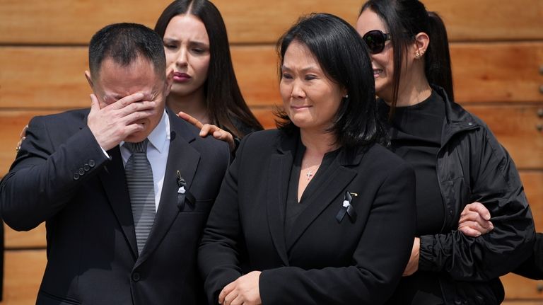 Keiko Fujimori, right, leaves her home with her brother Kenji...