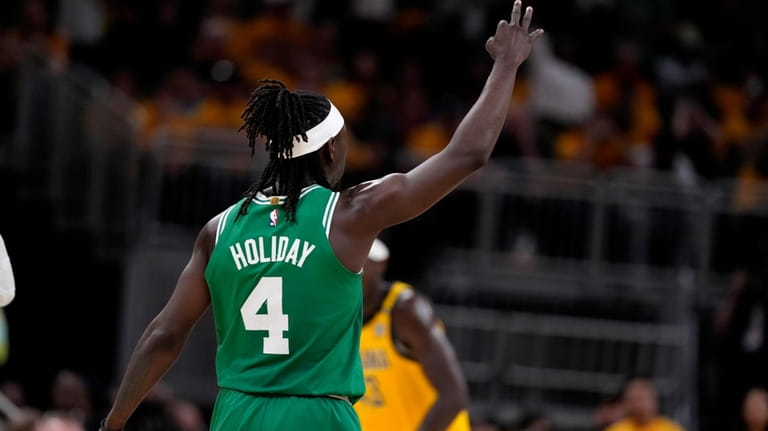 Boston Celtics guard Jrue Holiday celebrates after making a three-point...
