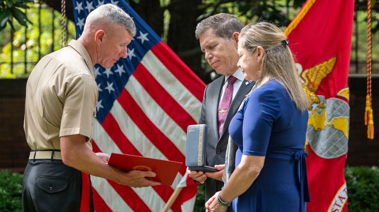 Commandant of the Marine Corps Gen. Eric Smith, left, presents...