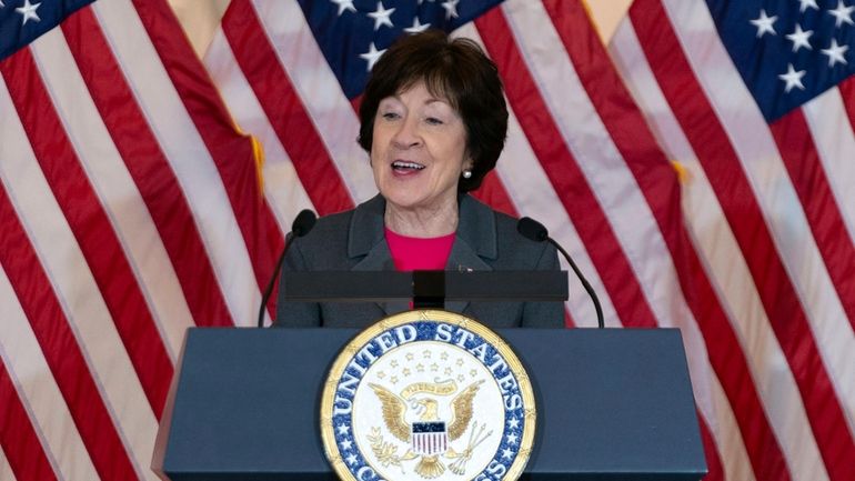 Sen. Susan Collins, R-Maine, speaks in front of American flags...