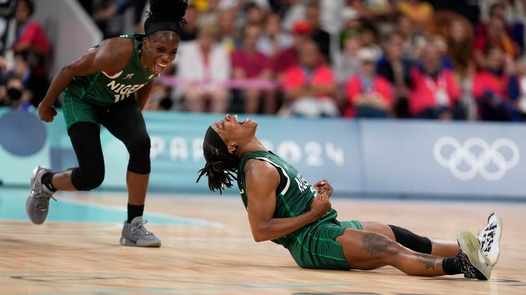 Ezinne Kalu (23), and Promise Amukamara (10), of Nigeria, celebrate...