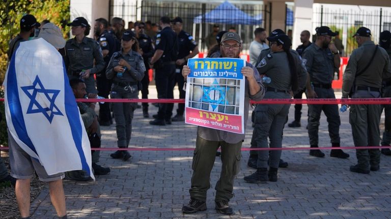 A right-wing Israelis protest outside of the initial hearing in...