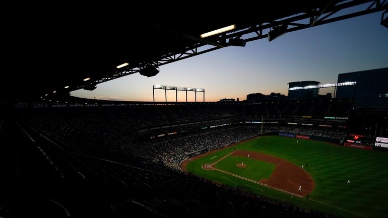 A crowd watches the fourth inning of a baseball game...