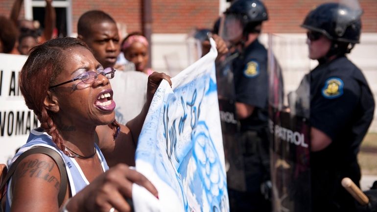 Marcelle Stewart, left, confronts police officers during a march and...