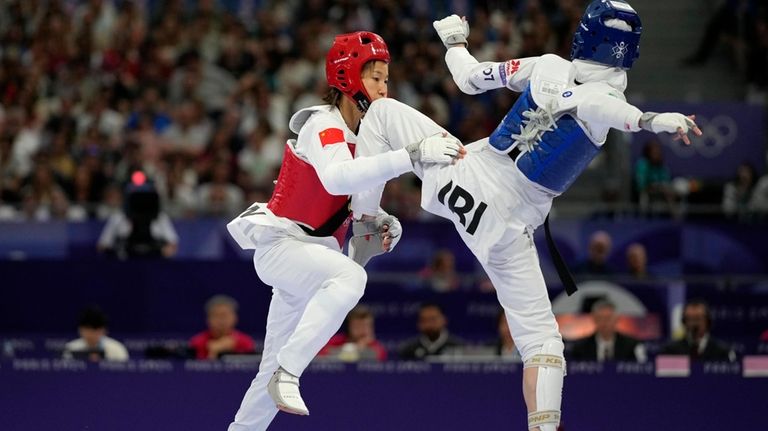 Iran's Mobina Nematzadeh competes with China's Guo Qing in a...